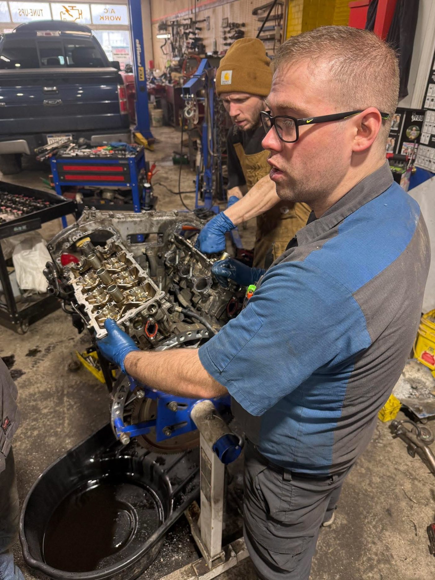 Neff's technicians inspecting cylinder heads on an engine stand